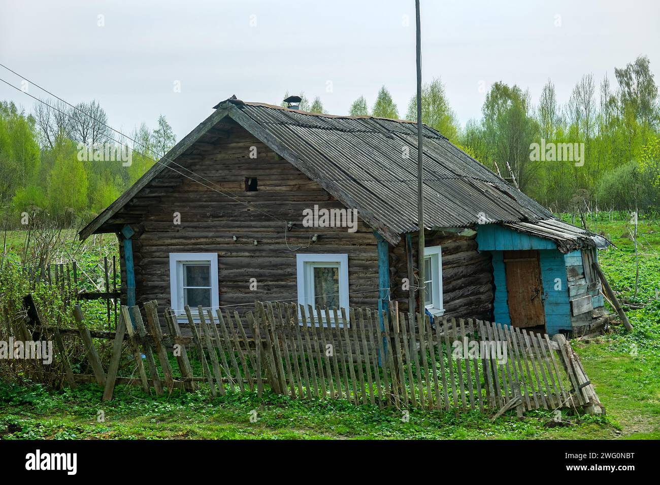 Wooden architecture. Old log-crib building (peasant cabin). General plan of building preserved, but wooden roof (shingles) replaced with slate, window Stock Photo