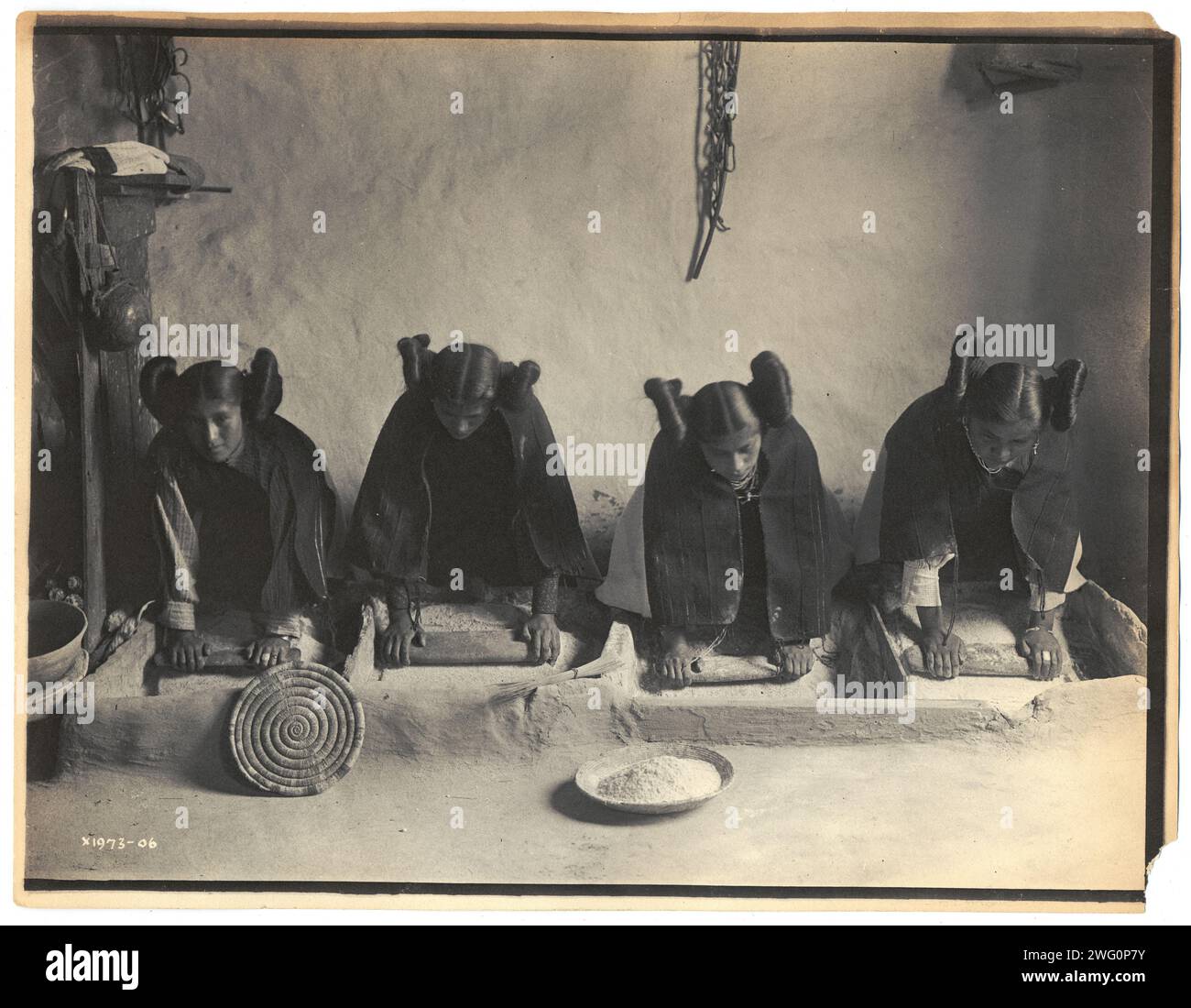 The mealing trough-Hopi, c1906. Photo shows four young Hopi Indian women grinding grain. Stock Photo