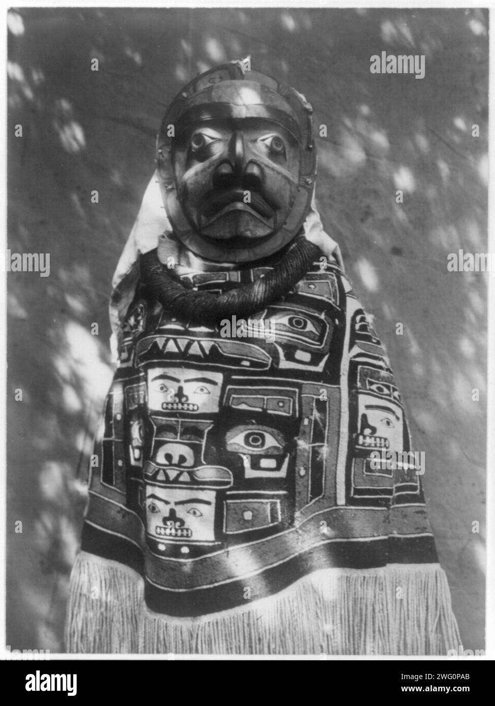 A Tluwulahu costume-Qagyuhl, c1914. Woman wearing a fringed Chilkat blanket, a hamatsa neckring and mask representing deceased relative who had been a shaman. Stock Photo