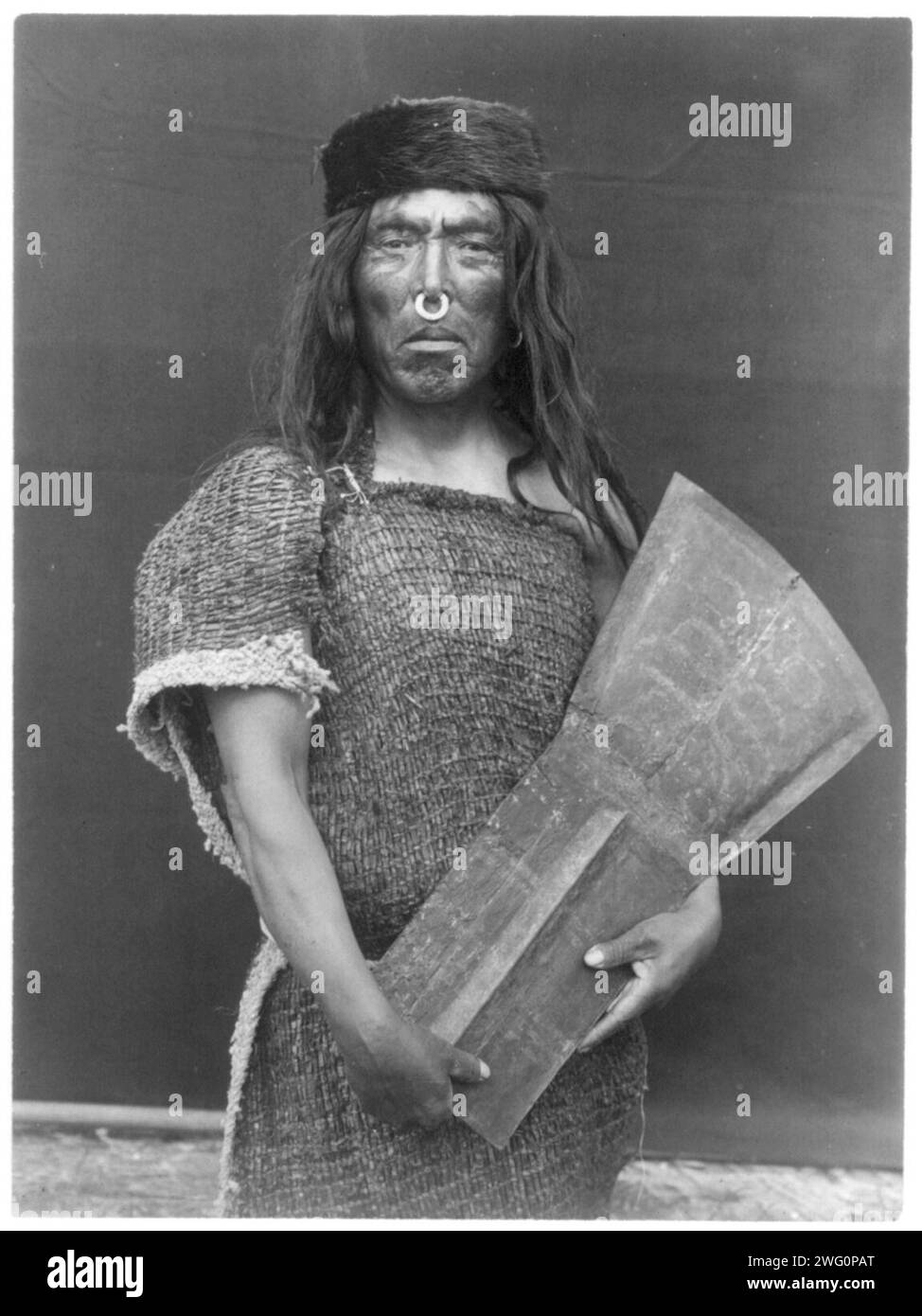 Nakoaktok chief and copper, c1914. Hakalahl, Nakoaktok chief, three-quarter length portrait, standing, facing front, holding copper Wanistakila (&quot;takes everything out of the house&quot;-a reference to its value) Stock Photo