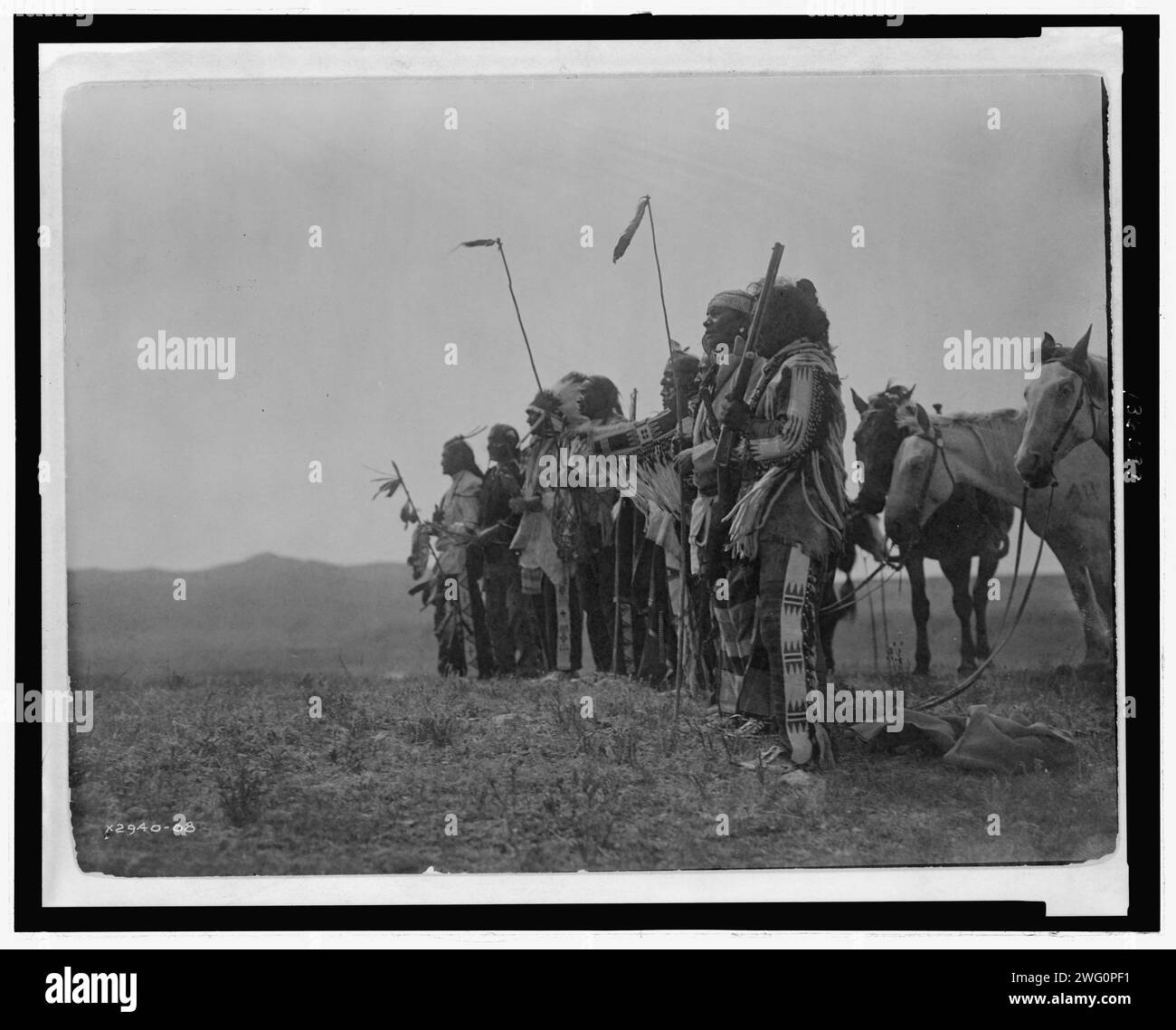 Awaiting the scouts return, Atsina, c1908. Photograph shows a group of Atsina men on a hill with their horses. Stock Photo