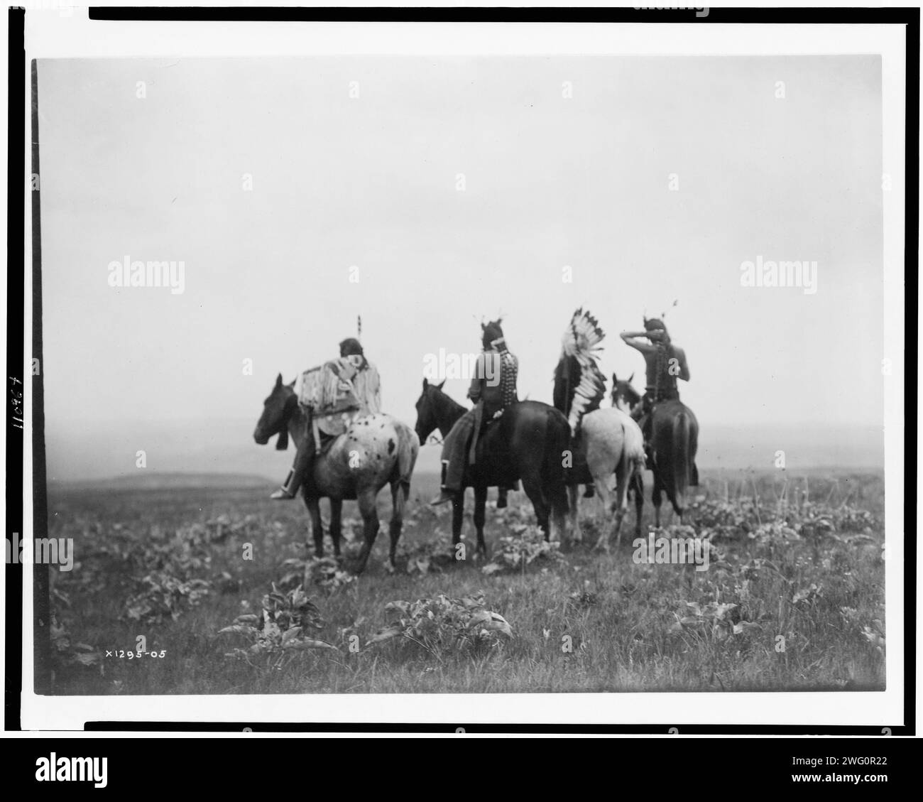 Absoraks, c1905. Rear view of four Crow Indians, including Shot in the Hand and Bull Chief, on horseback, Montana. Stock Photo