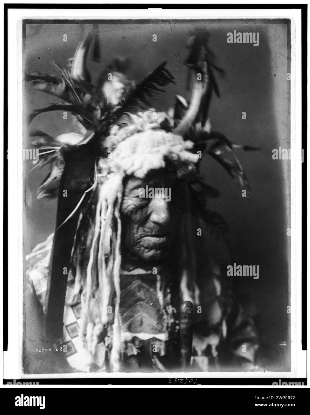 Lean Wolf-Hidatsa, c1908. Lean Wolf, head-and-shoulders portrait, facing right, wearing horn headdress trimmed in white fur and dark feathers, beaded buckskin shirt. Stock Photo