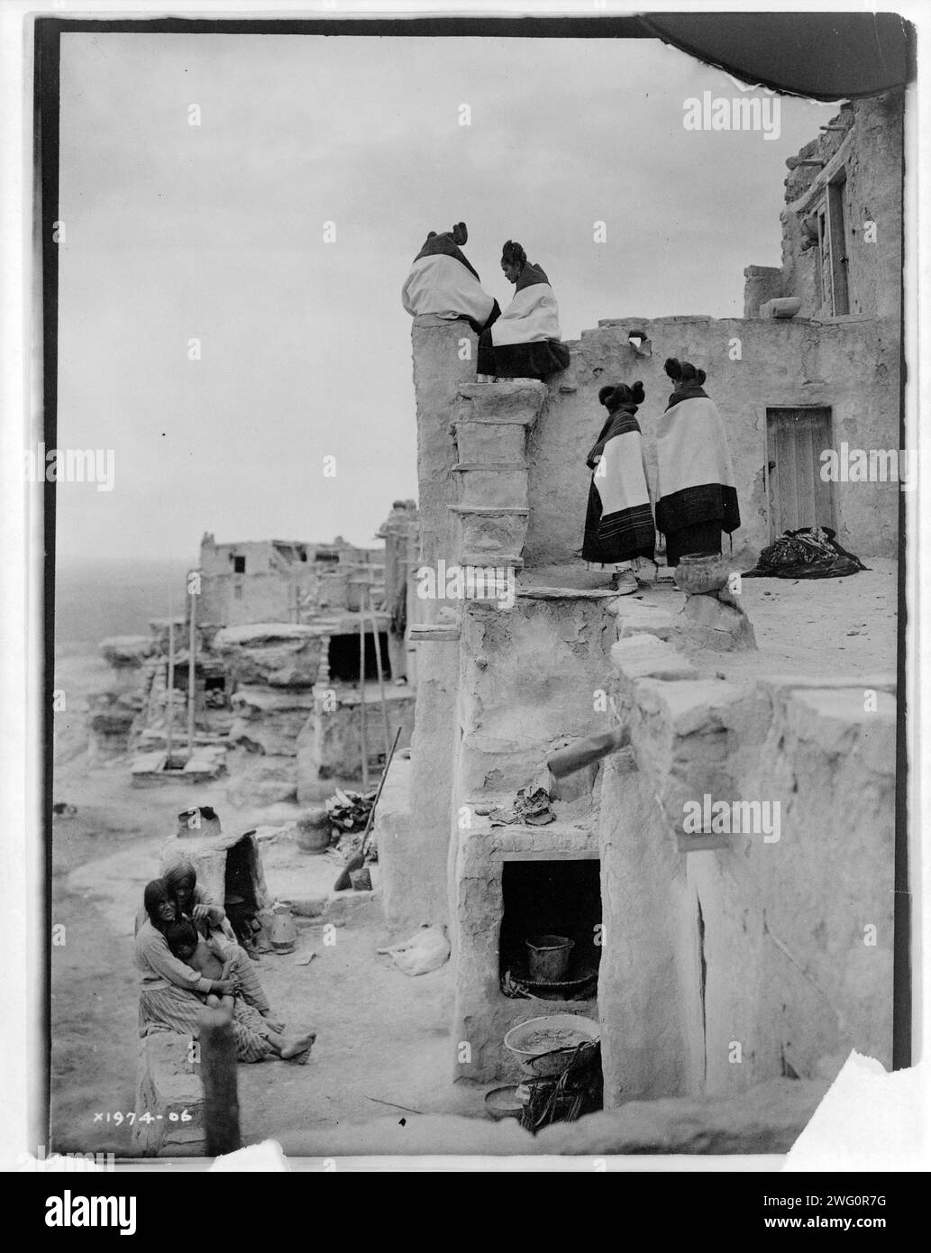 On the housetop-Hopi, c1906. Photo shows women seated and standing on pueblo buildings. Stock Photo