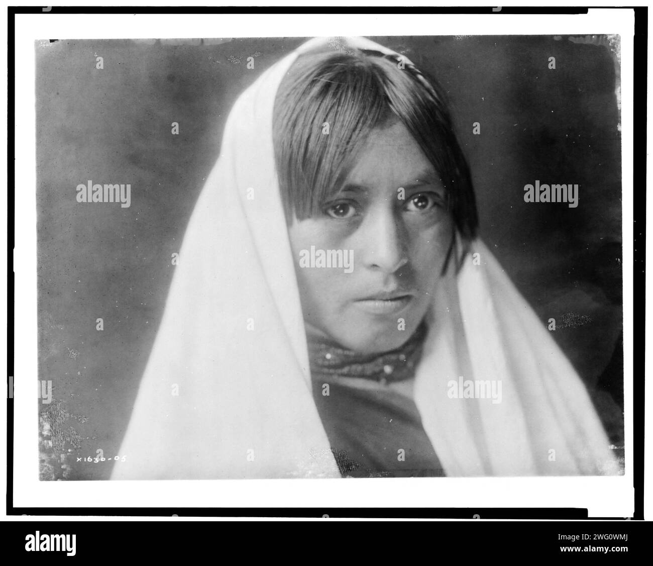 Walvia (&quot;Medicine Root&quot;)-Taos, c1905. Head-and-shoulders portrait of young woman facing front with shawl on head. Stock Photo