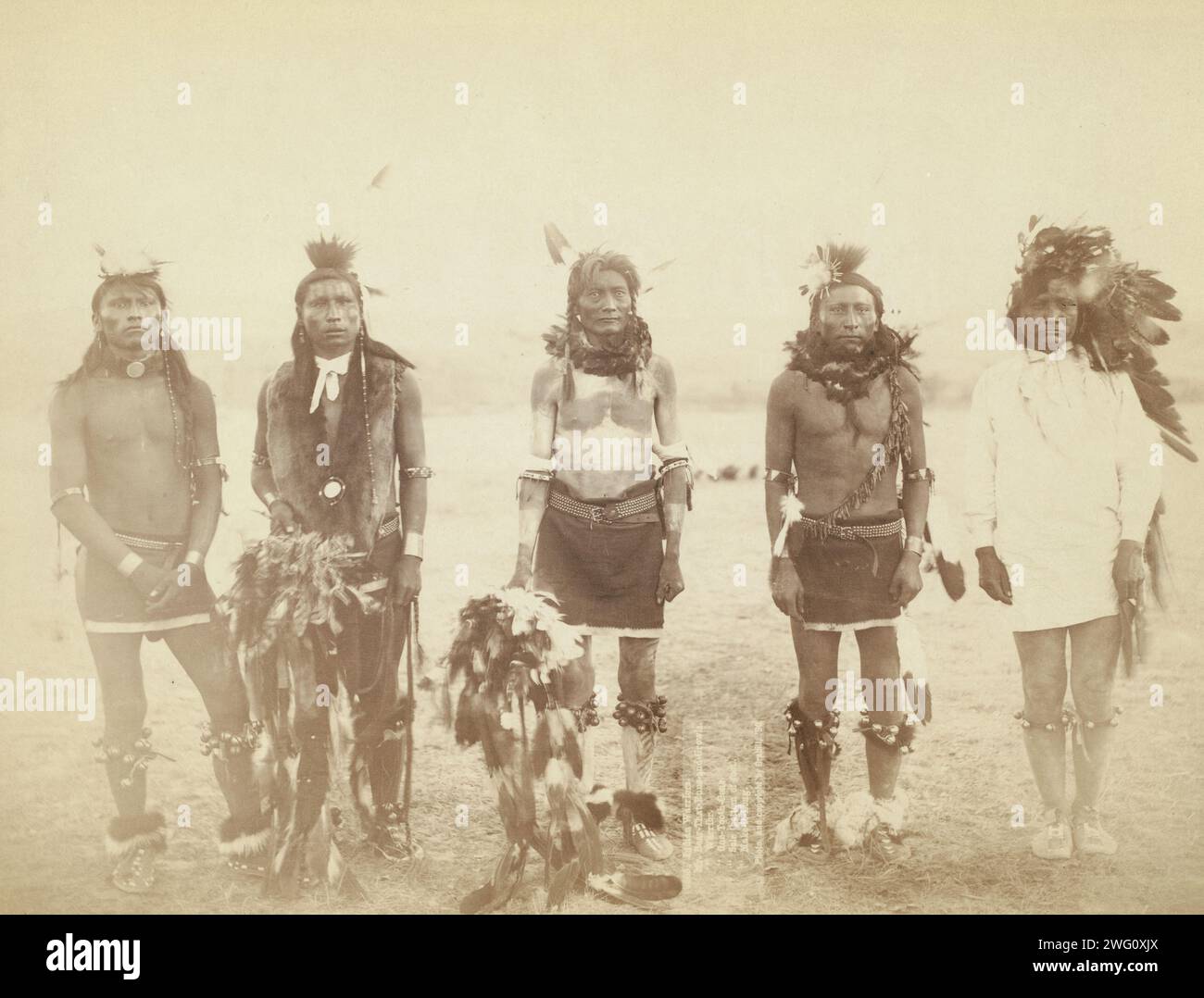 Indian Warriors. Mr. Bear-that-Runs-and-Growls, Mr. Warrior, Mr. One-Tooth-Gone, Mr. Sole (bottom of foot), Mr. Make-it-Long []. Five Grass dancers in ceremonial clothing, probably part of Big Foot's (Miniconjou) band at a Grass Dance on the Cheyenne River, S.D. on or near Cheyenne River Reservation. Stock Photo