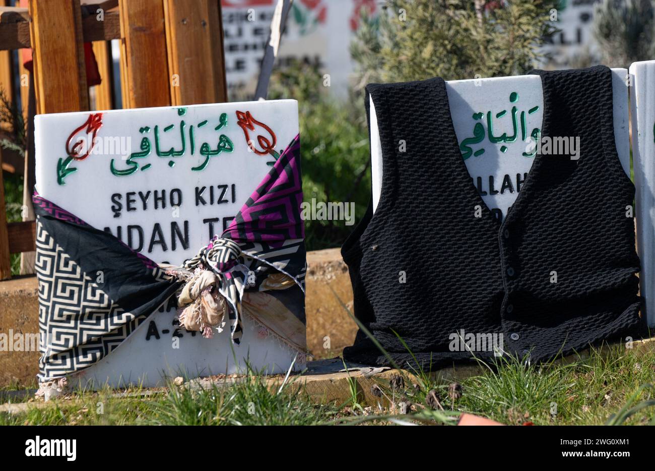 Adiyaman, Turkey. 02nd Feb, 2024. Personal belongings of the deceased lie on gravestones in a cemetery on the outskirts of Adiyaman in Turkey. Shortly before the first anniversary of the earthquake disaster, hundreds of relatives come to the graves of their loved ones who died in the quake on February 6, 2023. Credit: Boris Roessler/dpa/Alamy Live News Stock Photo