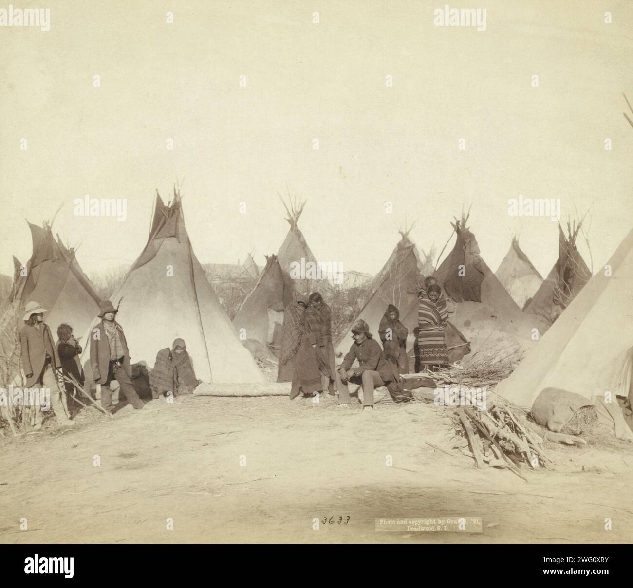 What's left of Big Foot's band, 1891. Group of twelve Miniconjou (children and adults), many are looking away from camera, in a tepee camp, probably on or near Pine Ridge Reservation. Stock Photo