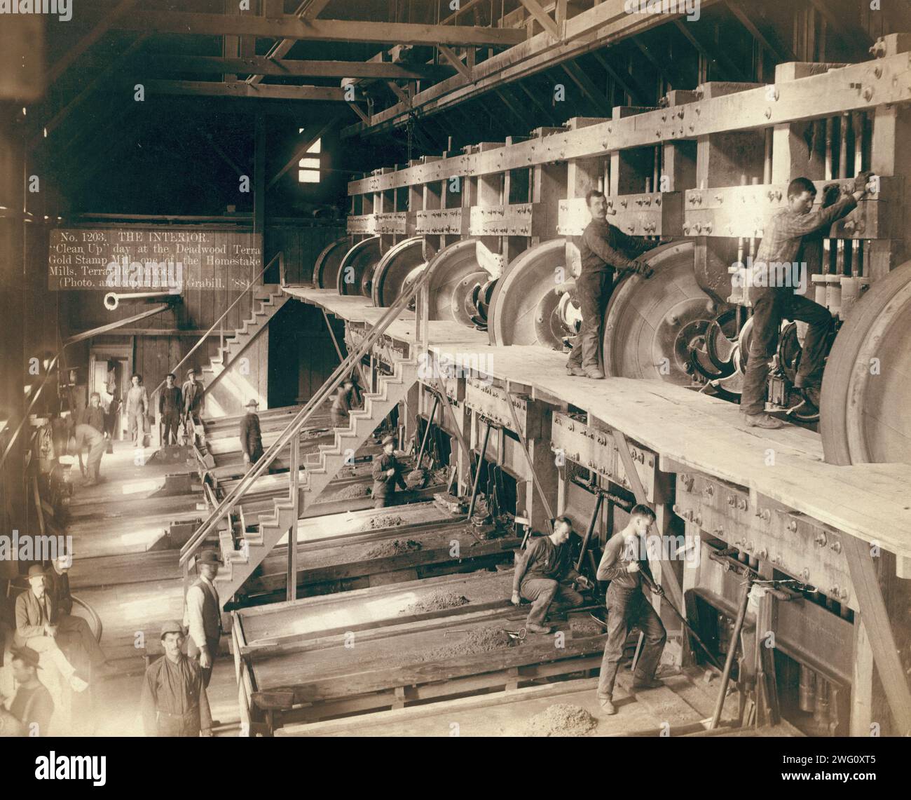 The Interior. &quot;Clean Up&quot; day at the Deadwood Terra Gold Stamp Mill, one of the Homestake Mills, Terraville, Dakota []. Interior of saw mill; men working on equipment. Stock Photo