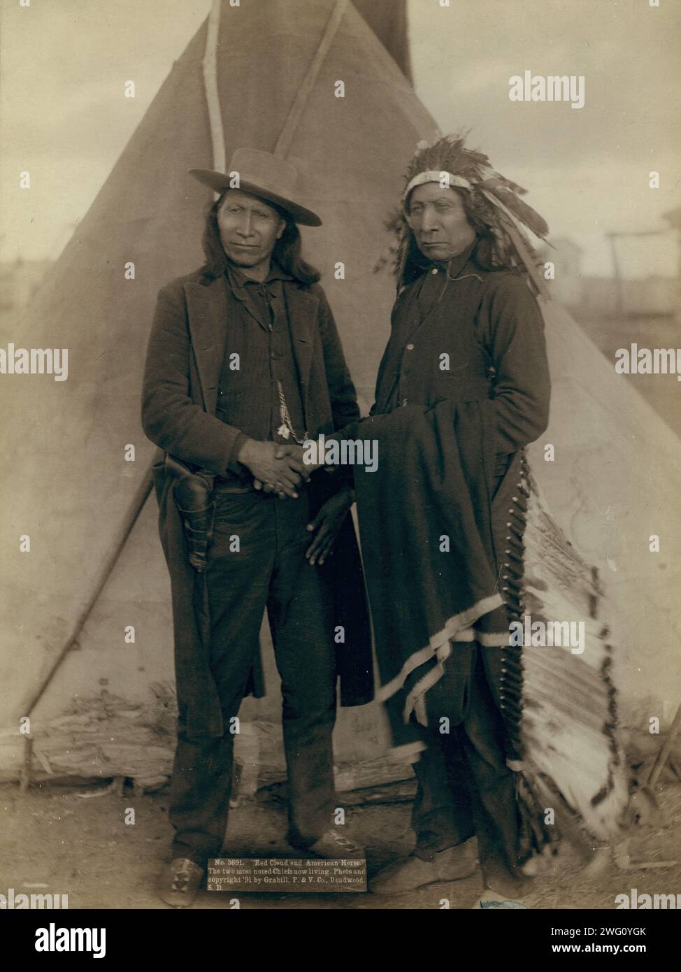 Red Cloud and American Horse The two most noted chiefs now living, 1891. Two Oglala chiefs, American Horse (wearing western clothing and gun-in-holster) and Red Cloud (wearing headdress), full-length portrait, facing front, shaking hands in front of tipi,probably on or near Pine Ridge Reservation. Stock Photo