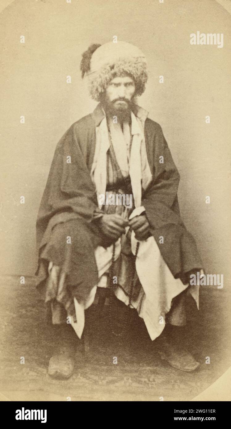 Full-length portrait of man, seated, facing front, between 1870 and 1886. Inscribed on verso: Muezzin for manaret in Daghestan village. Stock Photo