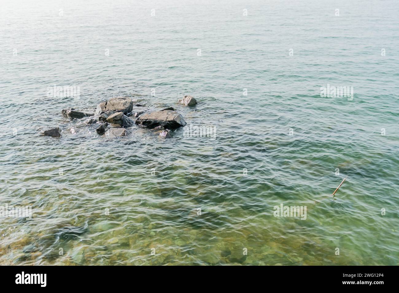 Waves lapping gently against large boulders at surface of water in Taean-gun, South Korea Stock Photo