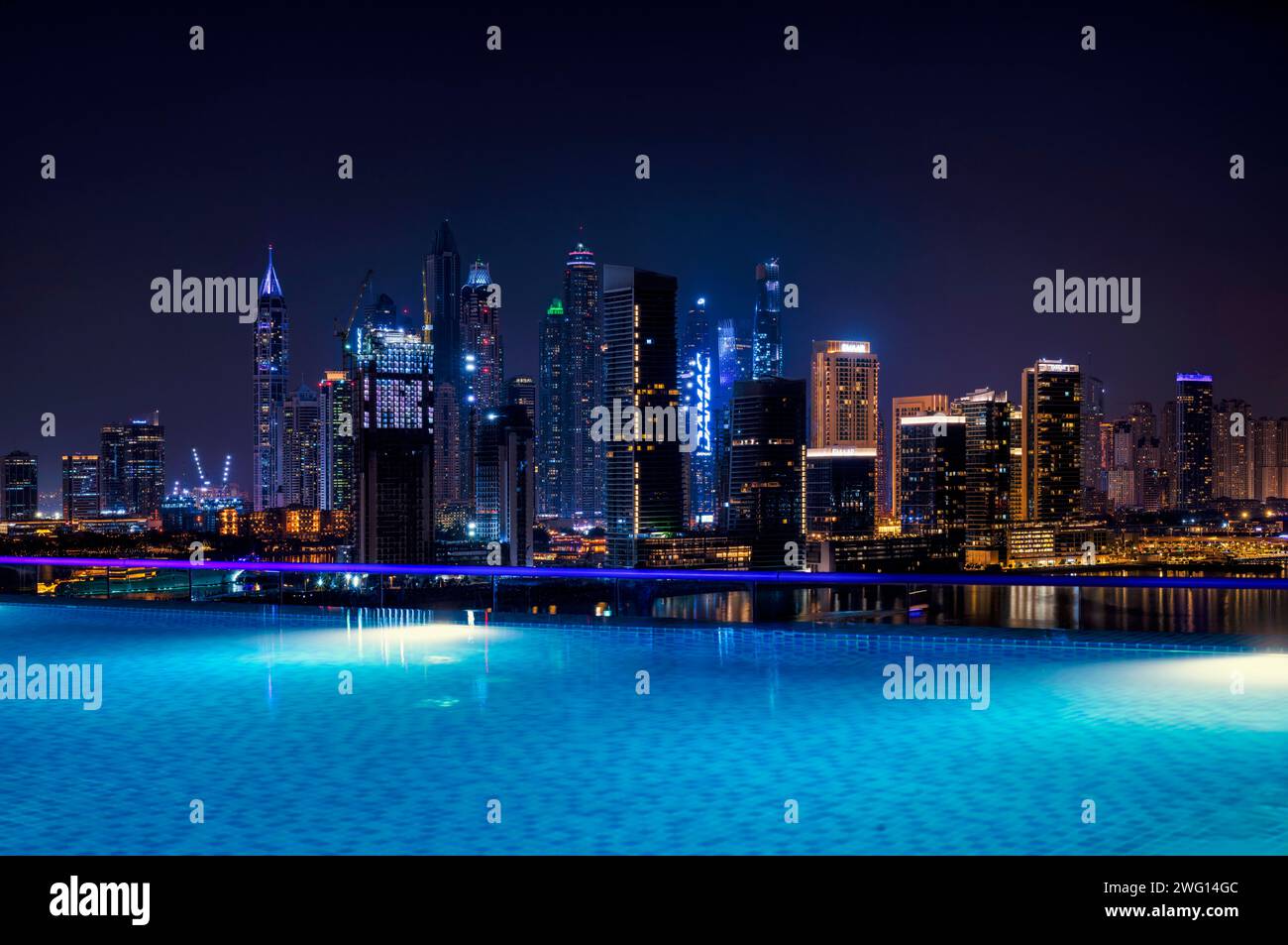 Night shot rooftop pool, swimming pool, Dubai Marina skyline behind