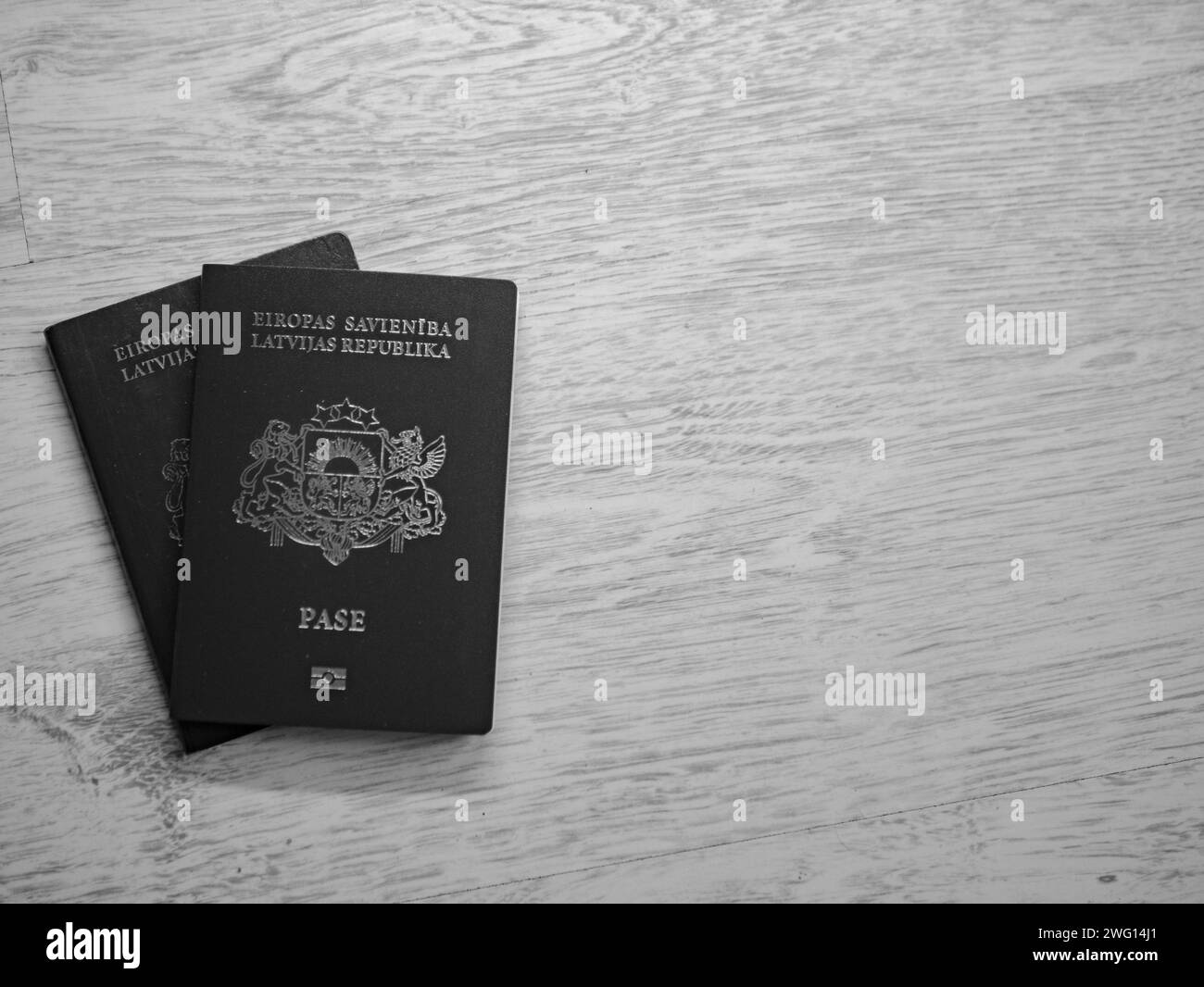 black and white Latvian european union passport on white wooden backround Stock Photo