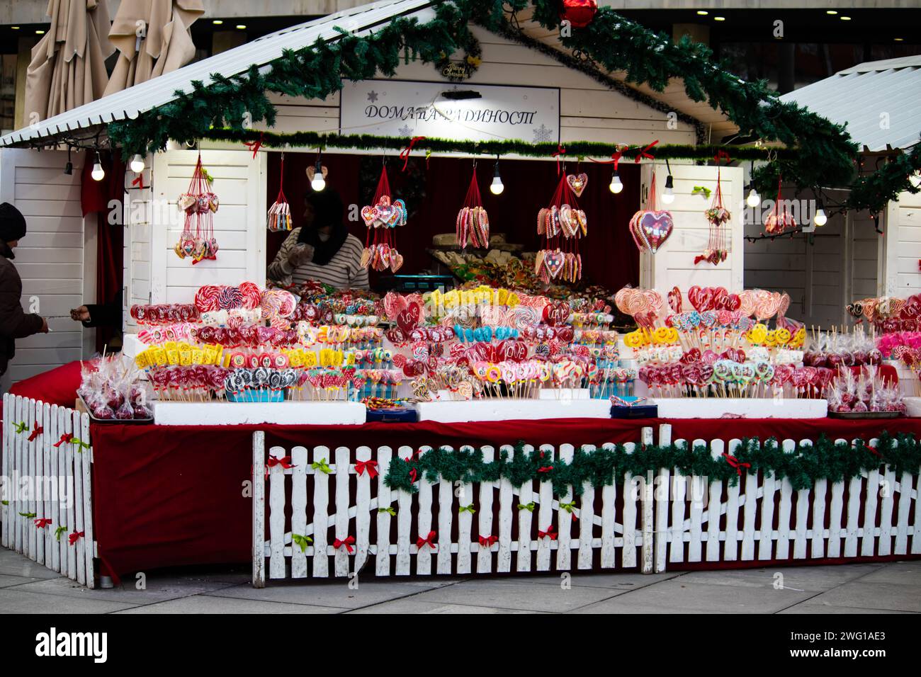 Colorful and attractive street candy shop full of sweets, lollipops, cakes, gummies, during winter holidays, New Year and Christmas season Stock Photo