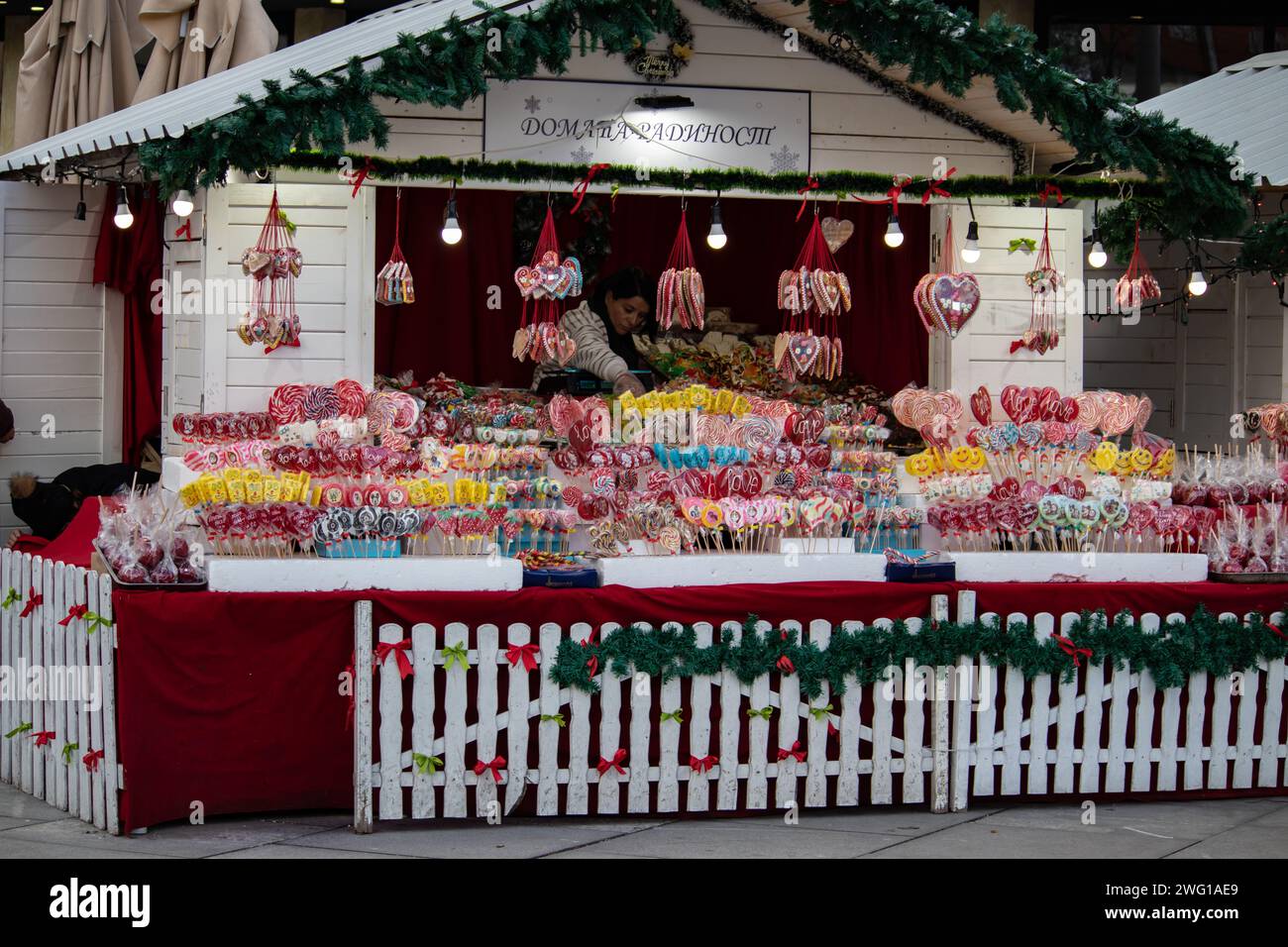 Colorful and attractive street candy shop full of sweets, lollipops, cakes, gummies, during winter holidays, New Year and Christmas season Stock Photo