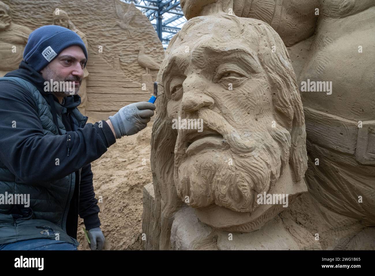Prora, Germany. 02nd Feb, 2024. Bagrat Stepanyan, sculptor, works on the sand sculpture Klaus Störtebeker on the grounds of the sand sculpture festival. Artists from several European countries are currently creating sand sculptures on the island of Rügen. Credit: Stefan Sauer/dpa/Alamy Live News Stock Photo