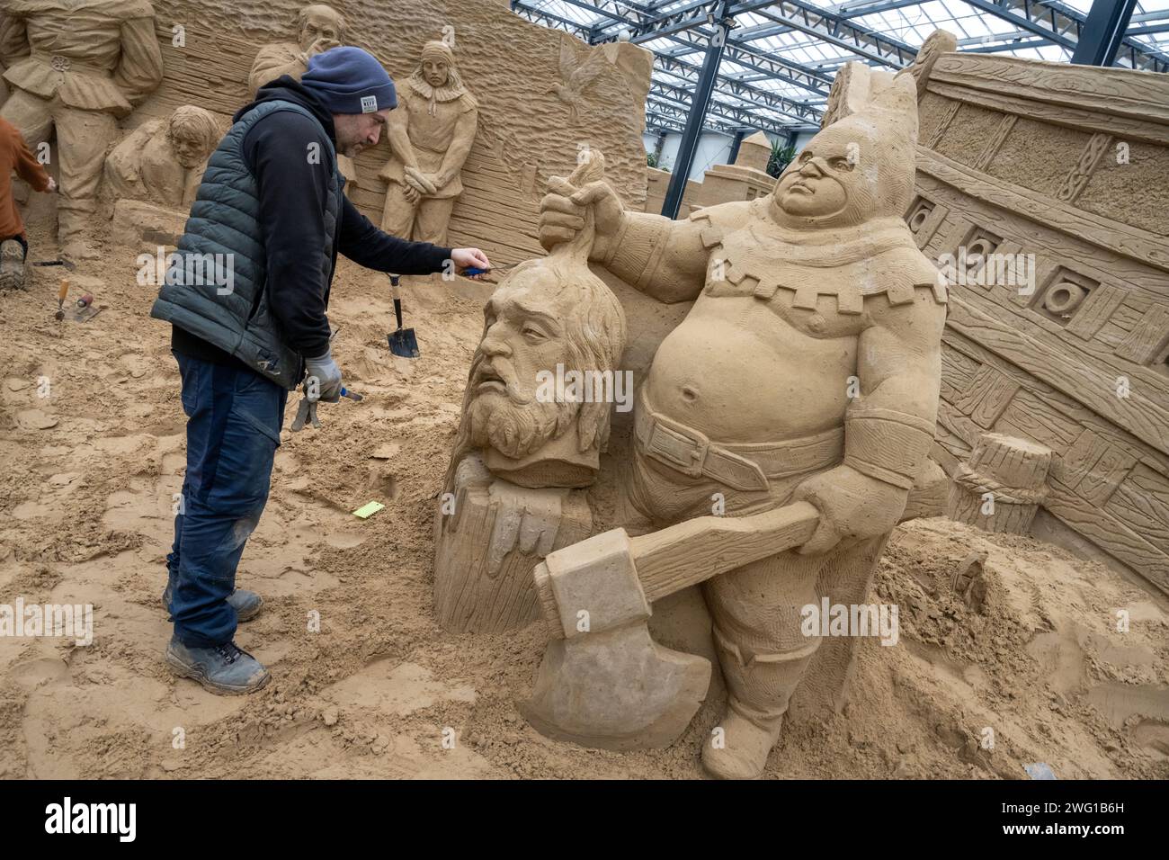 Prora, Germany. 02nd Feb, 2024. Bagrat Stepanyan, sculptor, works on the sand sculpture Klaus Störtebeker on the grounds of the sand sculpture festival. Artists from several European countries are currently creating sand sculptures on the island of Rügen. Credit: Stefan Sauer/dpa/Alamy Live News Stock Photo