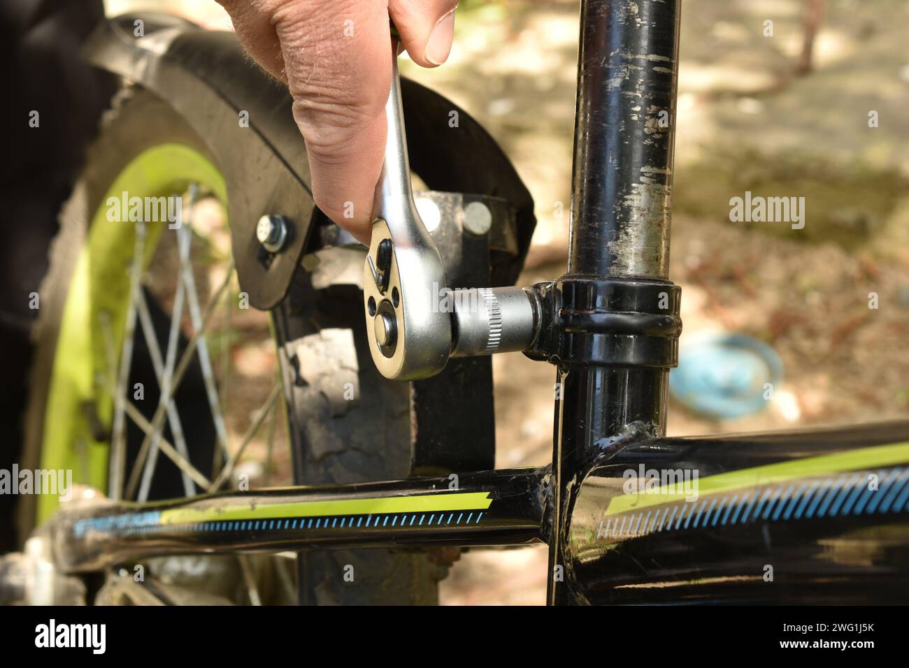 Men's hands hold a wrench with a ratchet, which is used to tighten a