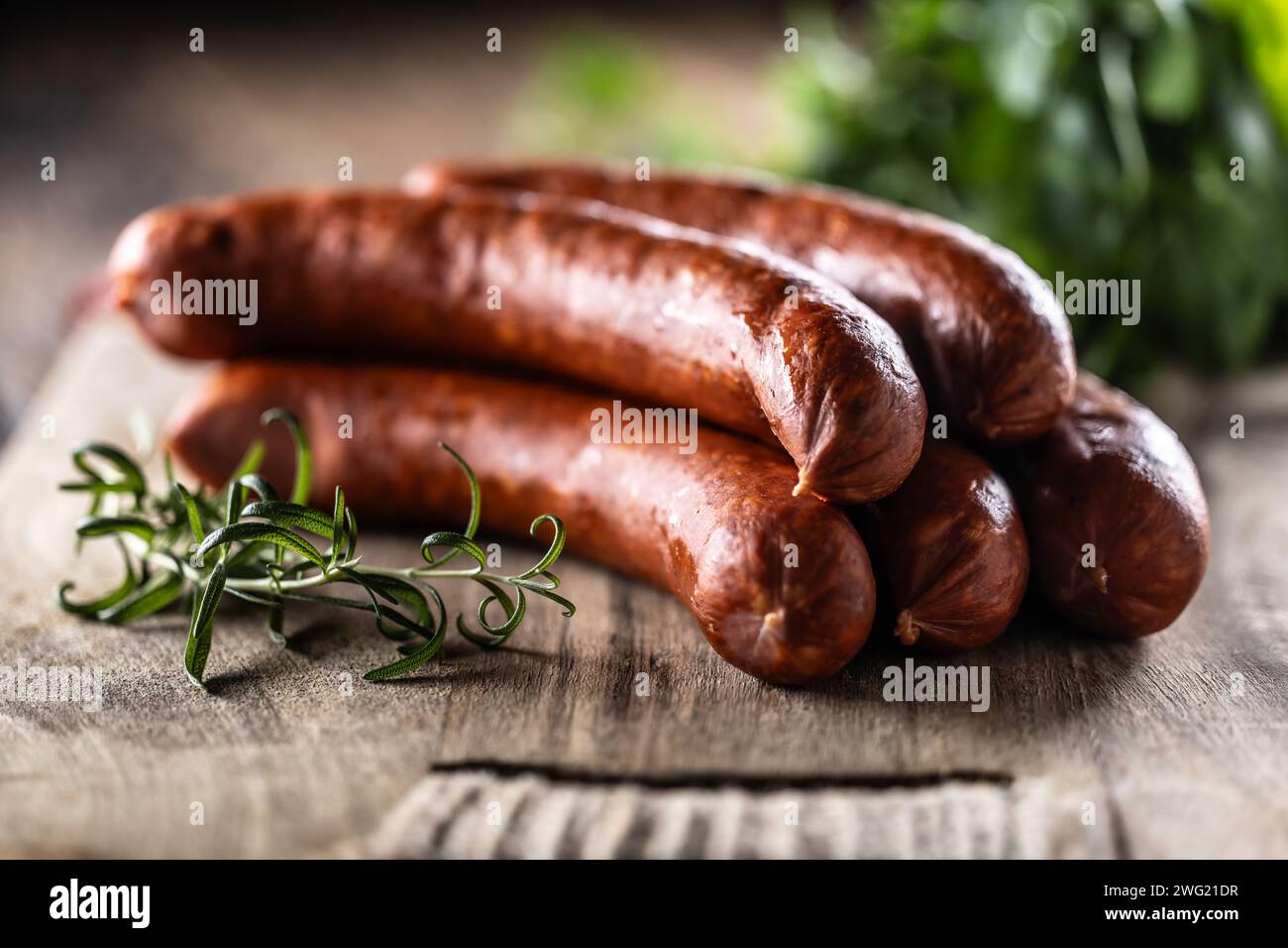Pepper pork smoked sausages with rosemary on a cutting board. Stock Photo