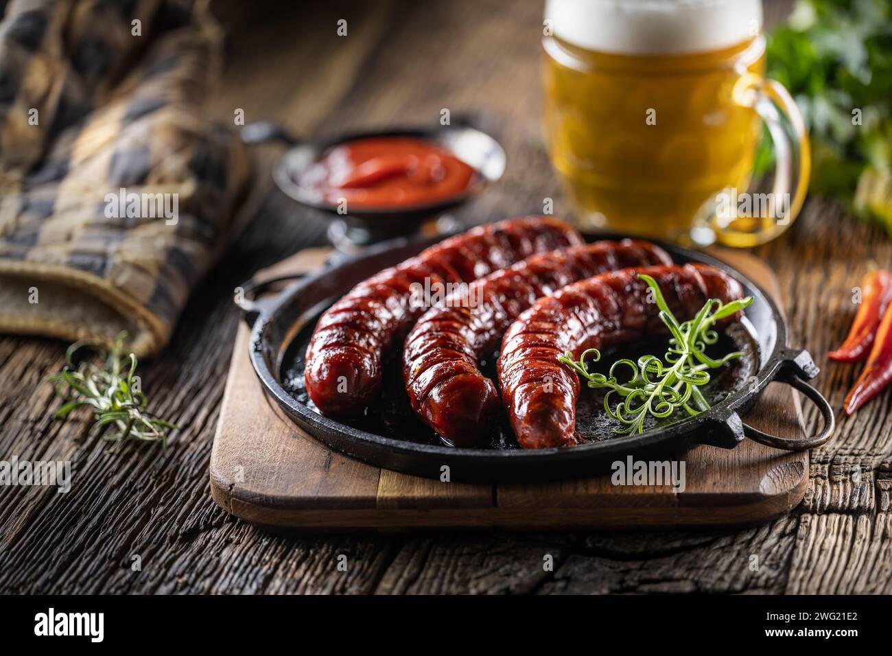 Sausages fried with spices bbq sauce draft beer and herbs - Close up. Stock Photo