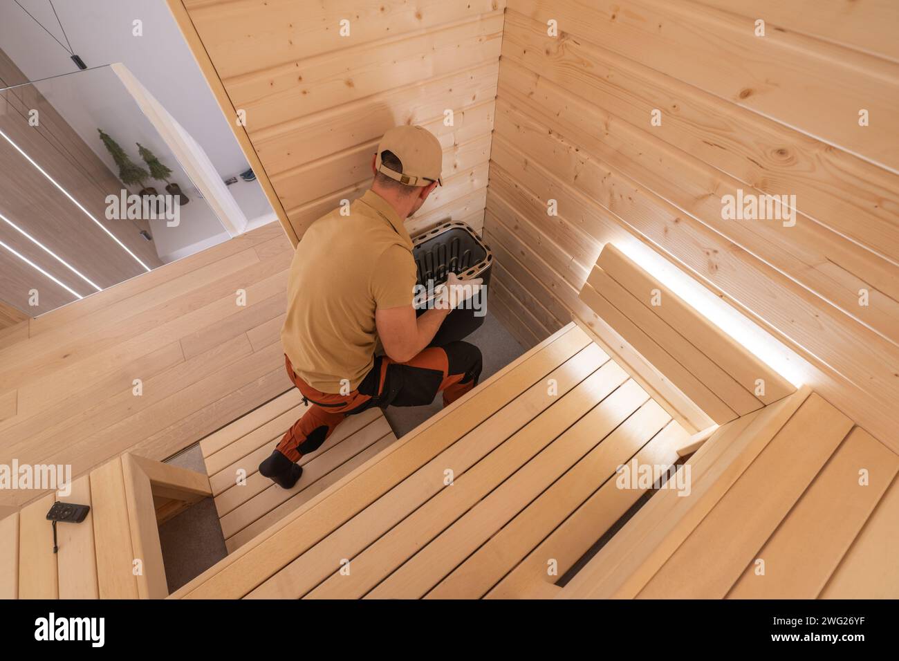Professional Sauna Builder in His 40s Finishing Residential Finnish Sauna Stock Photo