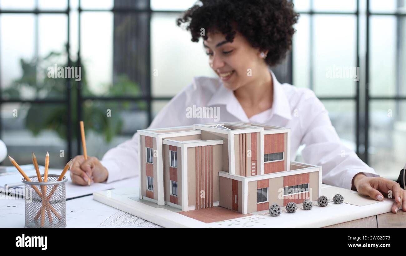 female architect designer examines house layout Stock Photo - Alamy