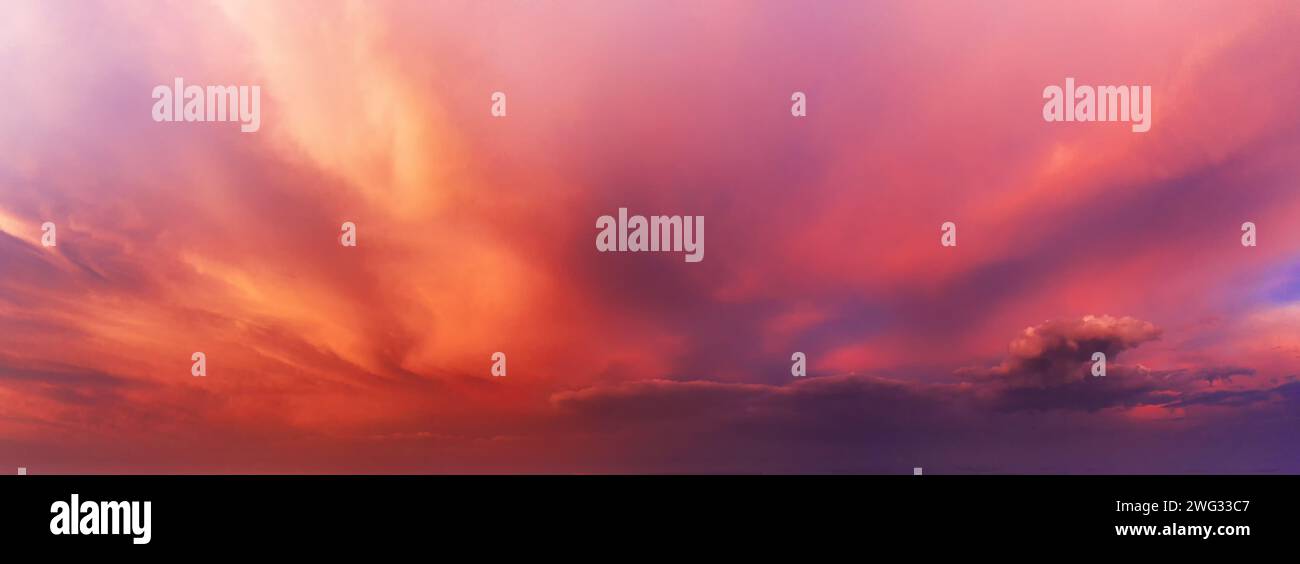Dramatic sky background with orange and purple clouds at sunset. Stock Photo