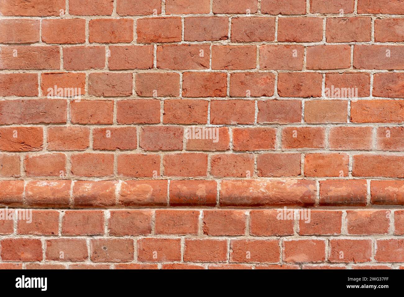 Wall texture with red bricks, geometric background with horizontal row of protruding, round red bricks, Background with copy space Stock Photo