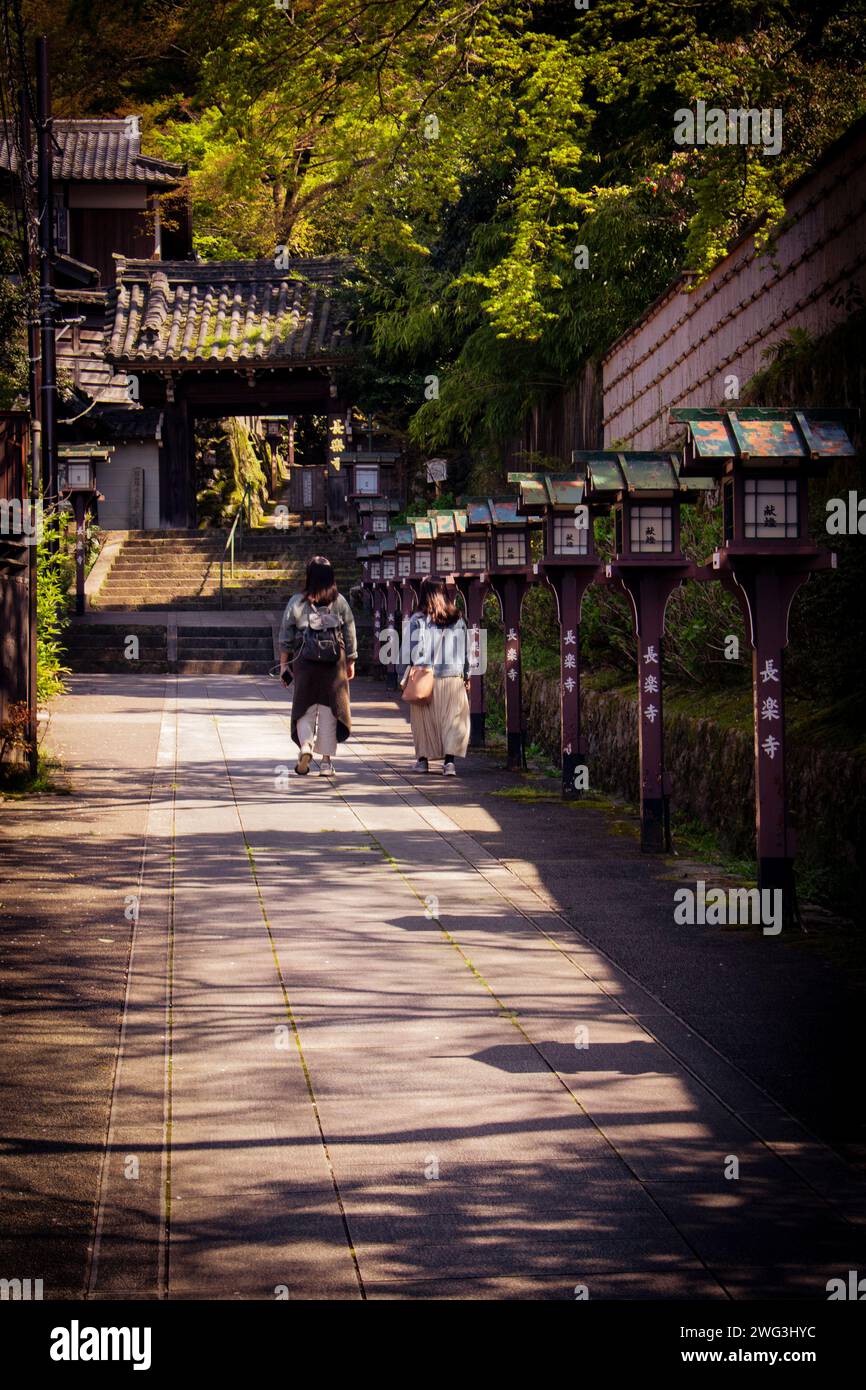 Two women walking towards tha gate of Chorakuji Temple in Kyoto Stock Photo