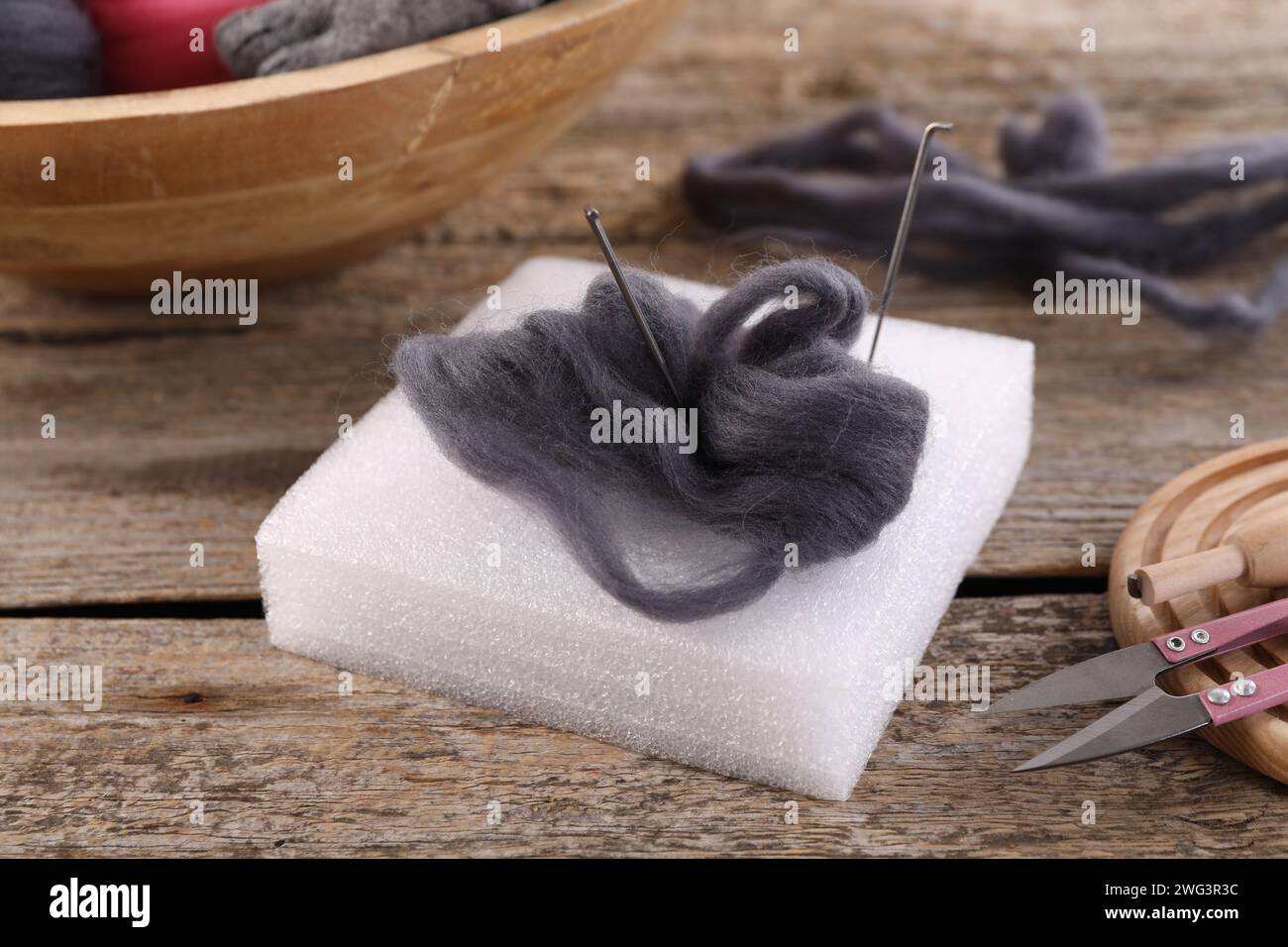 Felting tools and wool on wooden table, closeup Stock Photo