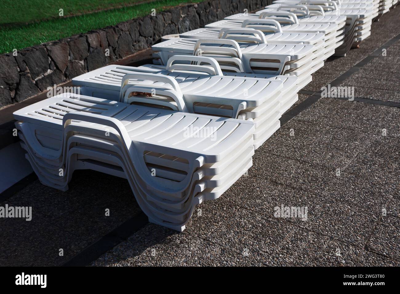 Row of white sun loungers on the ground in the aqua park Stock Photo