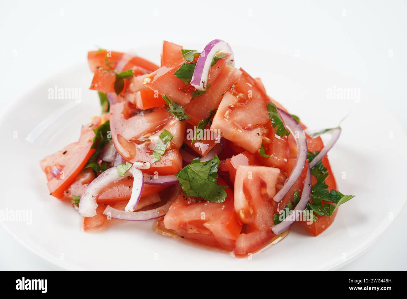 Salad with fresh tomatoes, olive oil, onions, parsley and fennel. Stock Photo