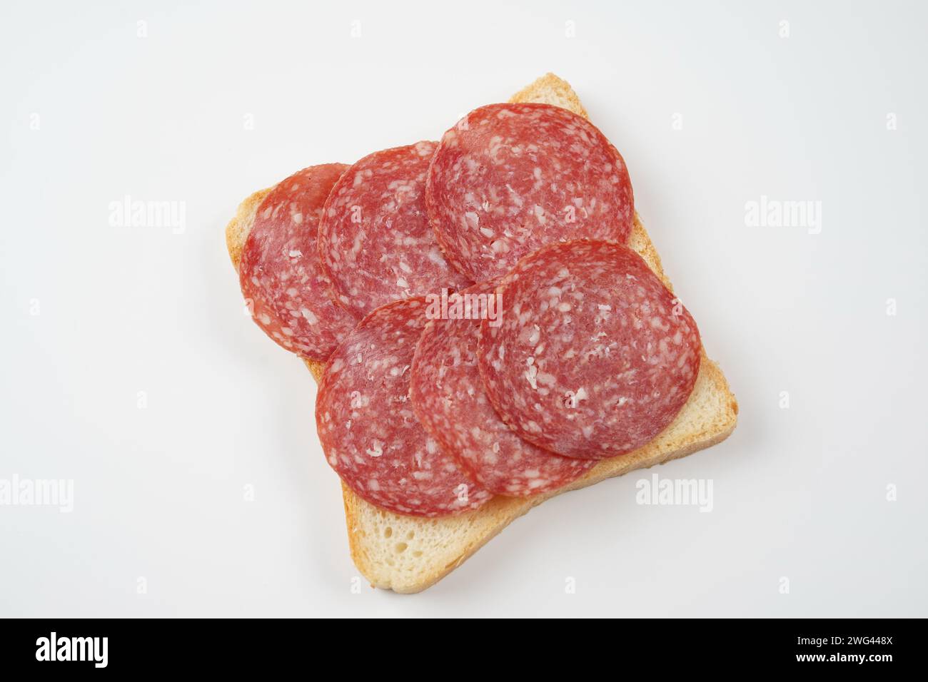 Salami sandwich. Open sandwich of salami slices, thin cut. Spanish salami with spices on  bread. Stock Photo