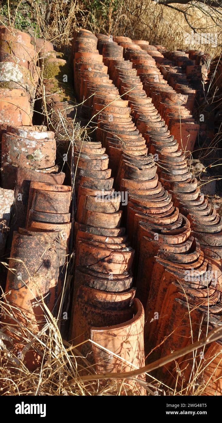 Hundreds of antique roof tiles piled in a row ready to be used for a new home. Stock Photo