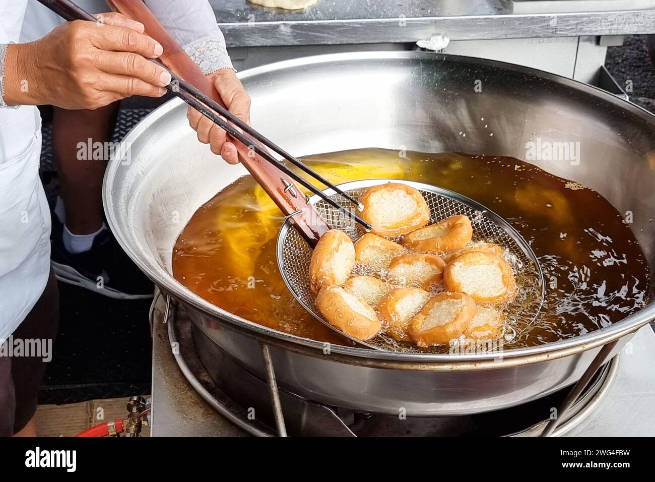 Hawker scooping out cooked Ham Chim Peng from wok, a popular Chinese street food in Malaysia Stock Photo