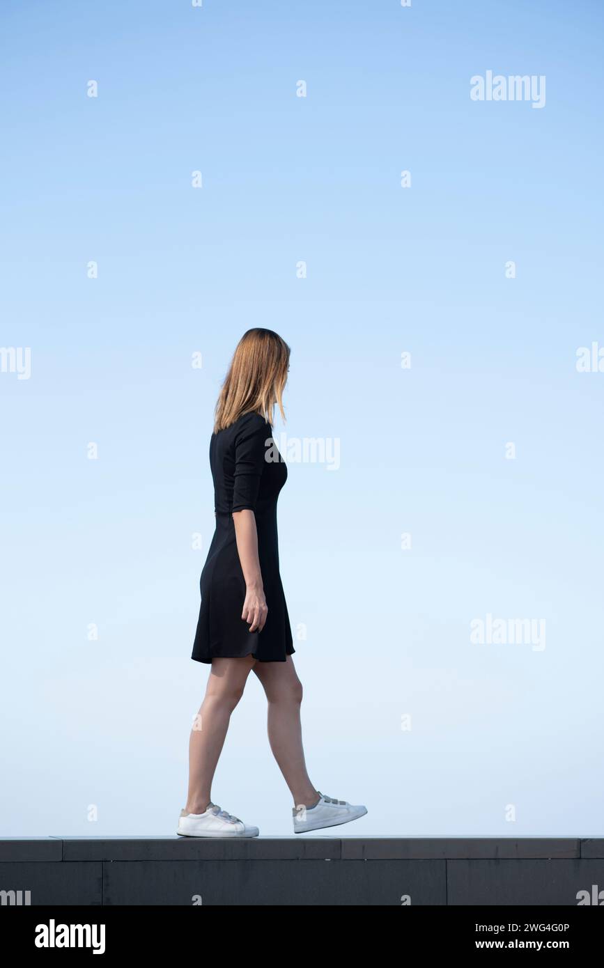 Side view of slim woman walking outdoors Stock Photo