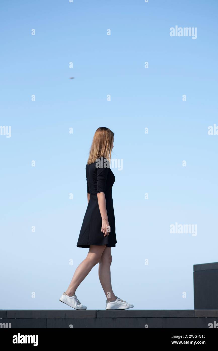Side view of slim woman walking outdoors Stock Photo