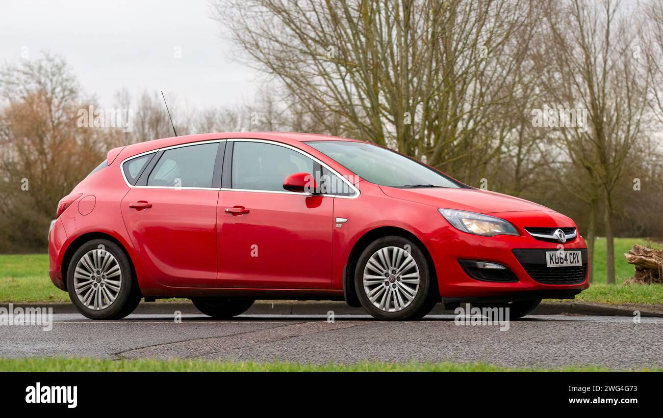 Milton Keynes,UK- Feb 2nd 2024: 2014 red Vauxhall Astra car driving on an English country road. Stock Photo