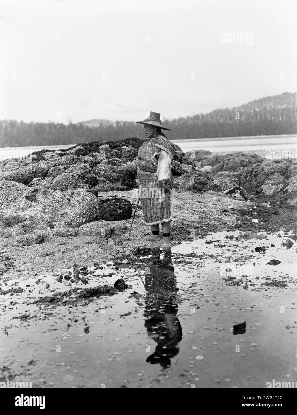 A hazy morning-Nakoaktok, c1910. Nakoaktok man standing on shore(?). Stock Photo
