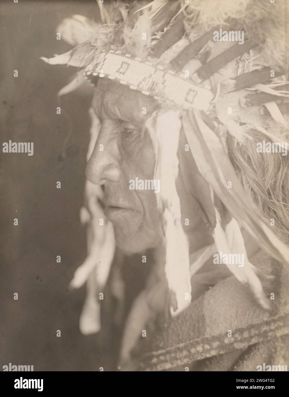 Ogalala Chief, 1905. Photograph shows an Ogalala Chief, wearing headdress, head-and-shoulders portrait, profile facing left. Stock Photo