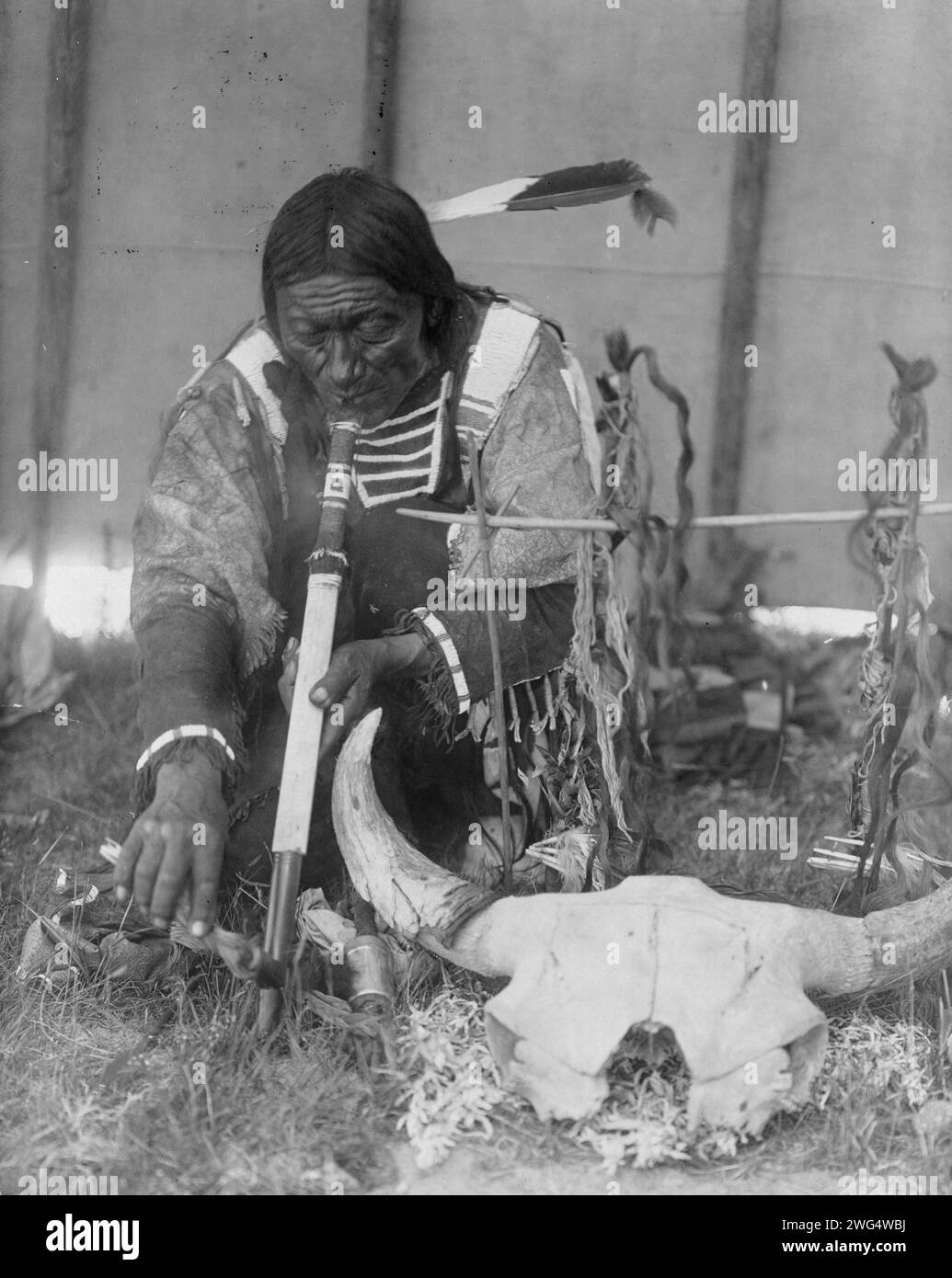 Saliva, c1907. Dakota man with calumet kneeling by altar inside tipi. Stock Photo