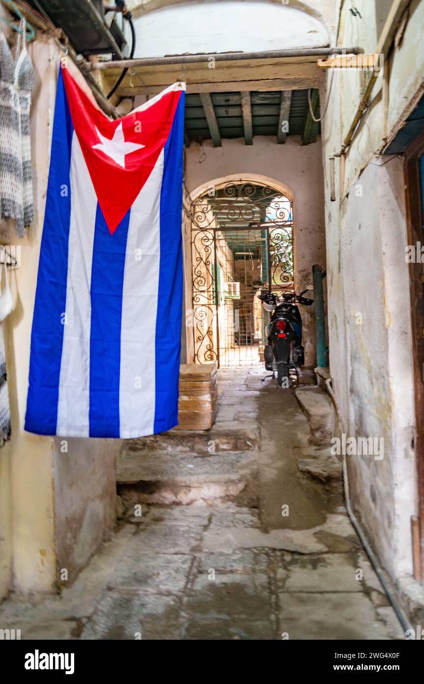 Authentic courtyard of a house on the street of Havana with a cuba flag and a motorcycle Stock Photo
