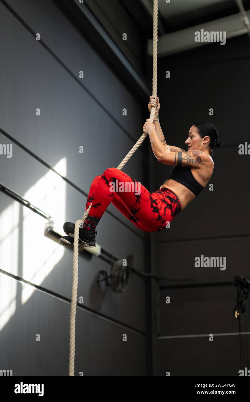 Woman Crossing Rope Woman climbing the rope in a gym hi-res stock photography and images ...