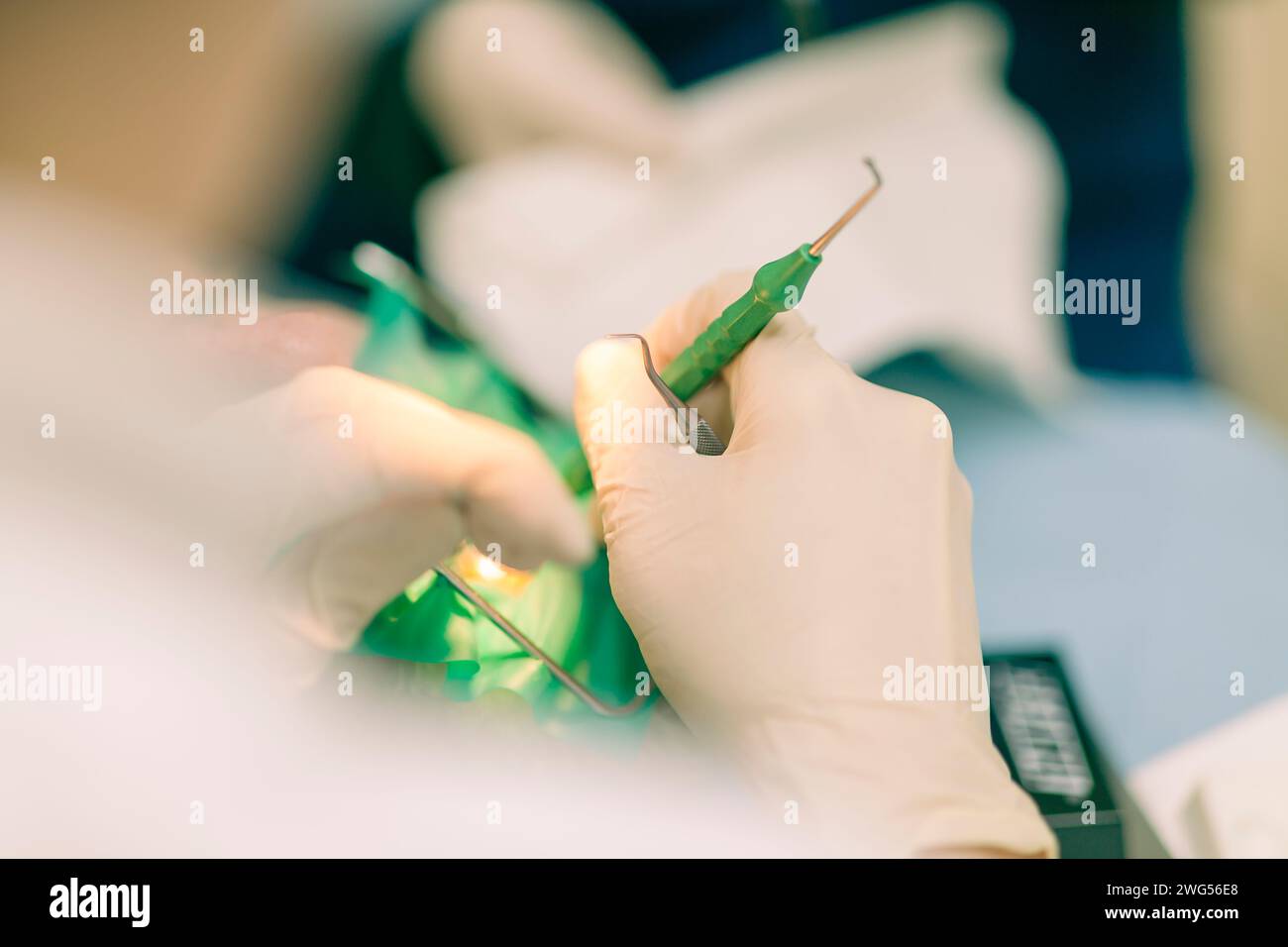 Detail of a dentist performing surgery with anesthesia on a patient for