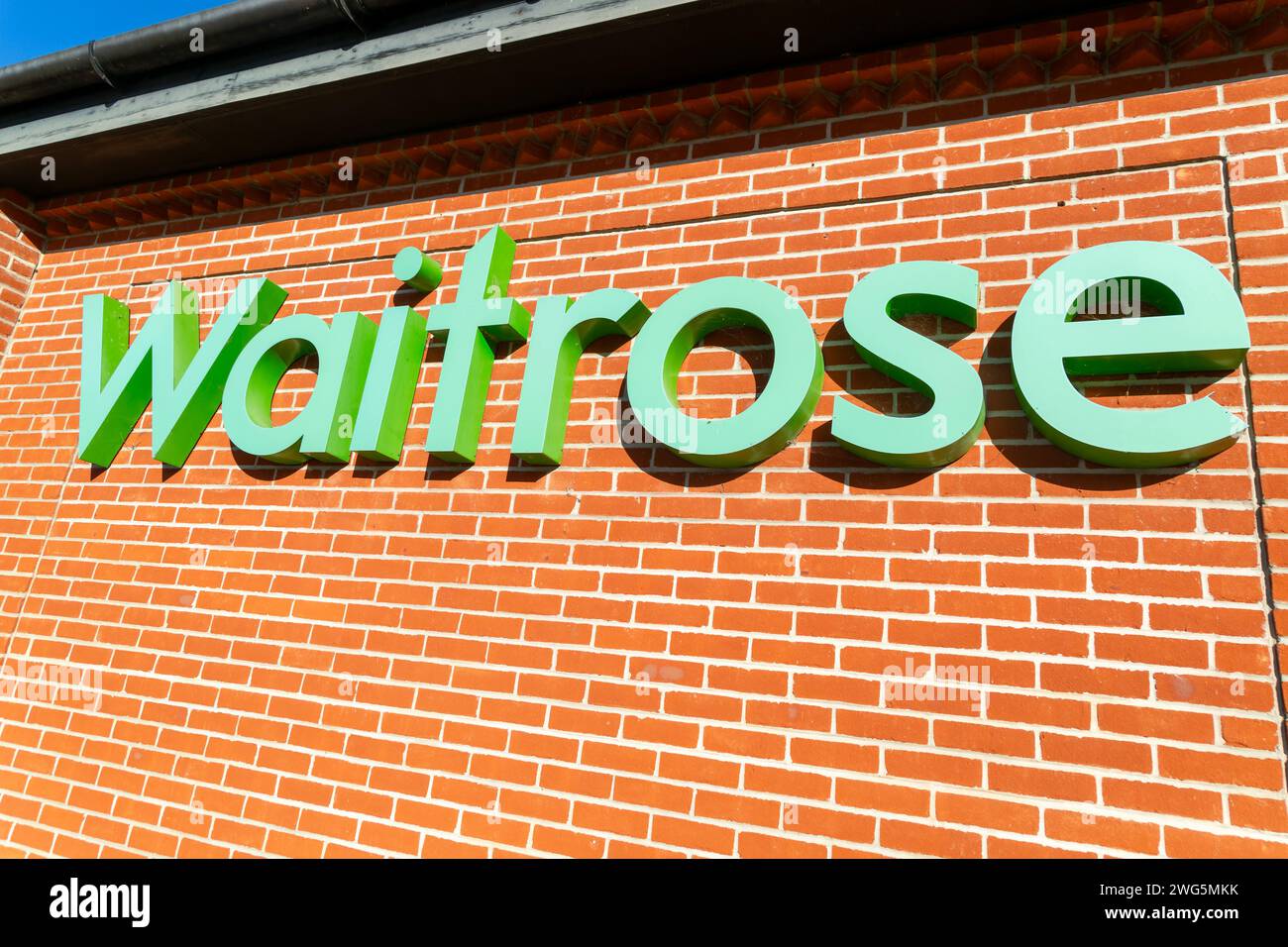 Waitrose shop sign on brick wall, UK Stock Photo