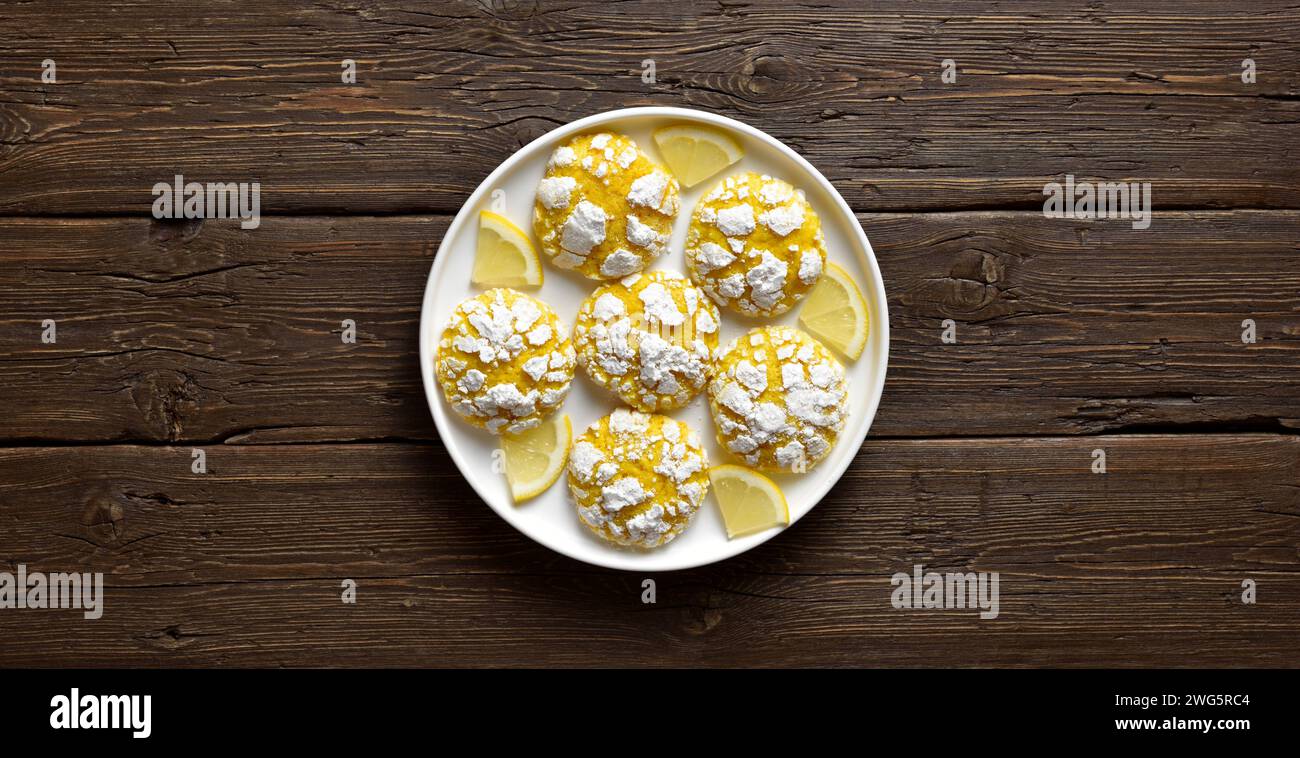Homemade citrus cookies with lemon on white plate over rustic wooden background with free space. Top view, flat lay Stock Photo