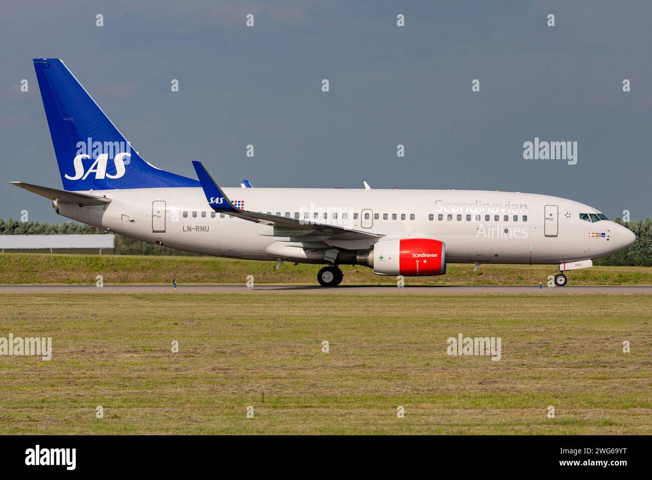 Scandinavian Airlines SAS Boeing 737-700 with registration LN-RNU rolling on taxiway V of Amsterdam Airport Schiphol Stock Photo