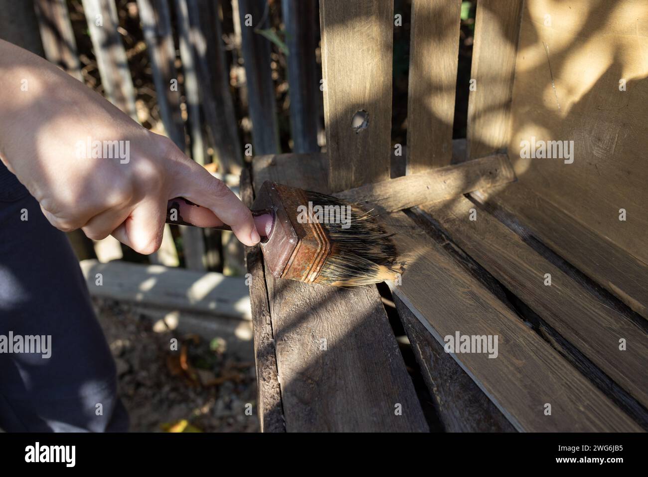 a child paints a wooden box with brushes in the garden Stock Photo