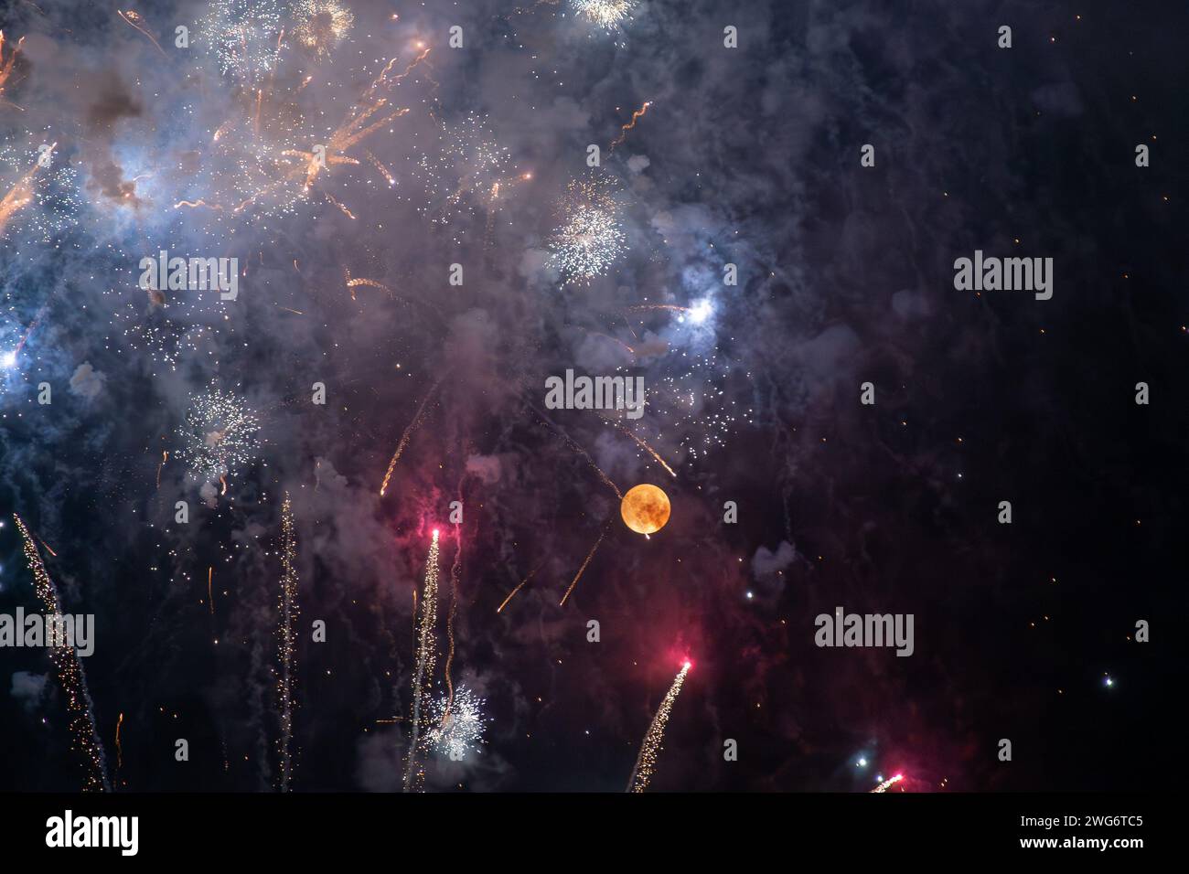 Night sky lit by full moon and fireworks for the Feast of the Madonna of Montallegro, patroness of Rapallo, Genoa, Liguria, Italy Stock Photo